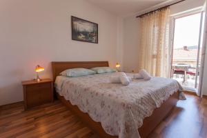 ein Schlafzimmer mit einem Bett und einem großen Fenster in der Unterkunft Apartman Budimir1 in Cres