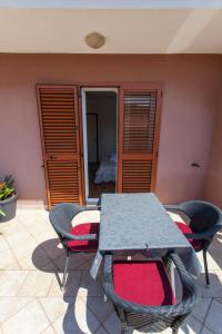 einen Tisch und Stühle auf einer Terrasse in der Unterkunft Apartman Budimir1 in Cres
