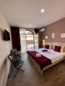 オフリドにあるZade Apartmentsの大きなベッドと大きな窓のある寝室