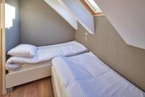a small room with two beds and a window at SosnowoMi - Całoroczne domy na wynajem in Lubiatowo +2 photos