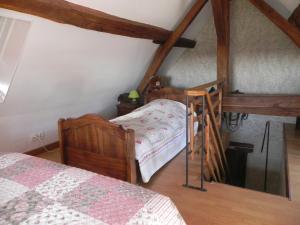 1 Schlafzimmer mit 2 Betten im Dachgeschoss in der Unterkunft Chambre d'hôtes Domaine de la Guinchère in LʼHôpital-le-Mercier