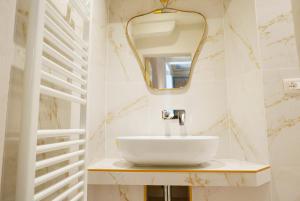 un baño con lavabo y espejo en Appartamenti Oriuolo, en Florencia 89 fotos más