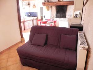 a couch with purple pillows in a living room at Chambre d'hôtes Domaine de la Guinchère in LʼHôpital-le-Mercier