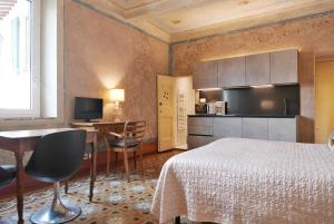 Un dormitorio con una cama y un escritorio y una cocina. en Appartamenti Oriuolo, en Florencia