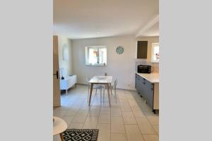 a kitchen and dining room with a table in it at Appt 1 à 4 pers Cocooning, ,1500 mètres sortie autoroute, 3 km Centre Mâcon in Mâcon