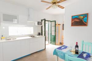 a kitchen with a table and a ceiling fan at Romantico con piscina privada solo para ti in Punta de Mujeres