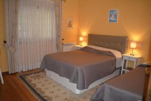 una camera con due letti e due lampade sui tavoli di Arouca Passadiços Alojamentos & Jacuzzi a Arouca Altre 42 foto