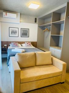 een woonkamer met een bank en een bed bij Smart Sharing Bela Vista in Sao Paulo