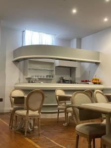 フィレンツェにあるホテル ロンバルディアの椅子とテーブル、キッチンが備わる客室です。