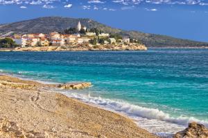 una playa con una ciudad en una colina en el océano en Apartments Primosten (600), en Primošten