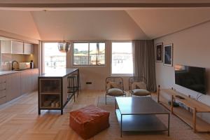een woonkamer met een tafel en een keuken bij Prime Riverside Duplex in Porto