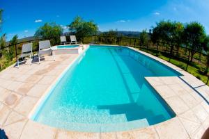 a swimming pool with chairs and a fence at Cabañas La Emilia Apart in Valle Grande
