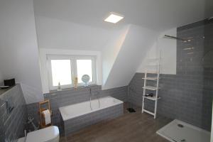 a bathroom with a bath tub and a window at 3100 - Kuhns Strandhus Grömitz in Grömitz +20 photos