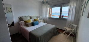 a bedroom with a bed with a view of the ocean at Vista Azul in Baiona