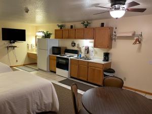 Whitetail Creek Resort في Lead: غرفة مع مطبخ مع سرير وطاولة