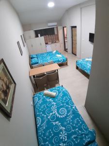 um dormitório com três camas e um taco no chão em Goka apartments em Gevgelija