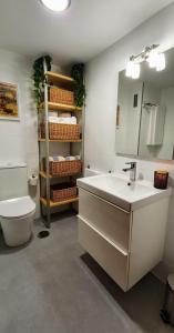 a bathroom with a sink and a toilet and a mirror at Vista Azul in Baiona