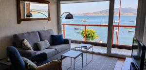 a living room with a couch and a view of the water at Vista Azul in Baiona