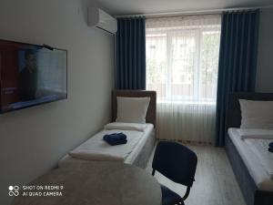 a room with two beds and a table and a tv at HotelRoom 1 in Uzhhorod