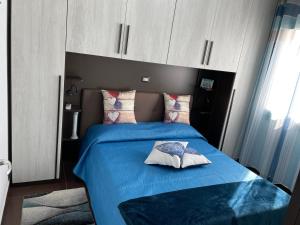 - une chambre avec un lit doté de draps bleus et d'oreillers roses dans l'établissement Blue Sardinia Tourism, à Budoni