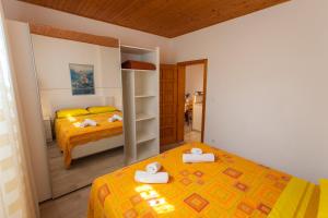 Un dormitorio con dos camas con toallas encima. en Apartman Budimir, en Cres