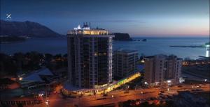un edificio alto con luces encima por la noche en Luxury Apartments Mia, en Budva
