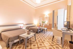 una camera d'albergo con due letti e una televisione di Hotel Belami a Maglie