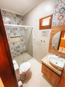 uma casa de banho com um chuveiro, um WC e um lavatório. em Pousada Vasto Horizonte em Barreirinhas