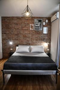 una cama en una habitación con una pared de ladrillo en Urban Holiday, en Roma
