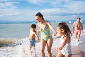 a family playing in the water at the beach at Playa Los Arcos in Puerto Vallarta