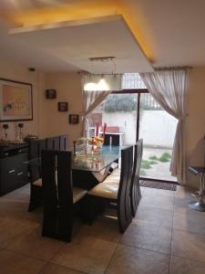 FAKALI Homestay في كيتو: غرفة طعام مع طاولة وكراسي زجاجية