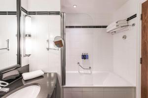 利兹Radisson Blu Hotel, Leeds City Centre的带浴缸和水槽的白色浴室