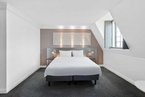 1 dormitorio con cama blanca y ventana en Radisson Blu Hotel, Leeds City Centre, en Leeds