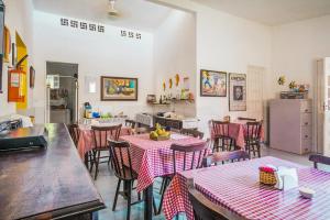 a restaurant with tables and chairs with red and white table cloth at Pousada Ciranda in Itamaracá