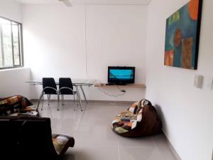 - un salon avec une table, des chaises et une télévision dans l'établissement Casa en condominio campestre, seguridad 24horas, cerca electrica y planta electrica, à Villeta