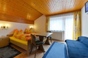 sypialnia z łóżkiem, biurkiem i stołem w obiekcie Ferienhaus in Klösterle w mieście Wilden