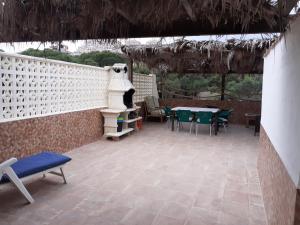 un patio con mesa, sillas y una valla blanca en La Manga Cala Del Pino, en La Manga del Mar Menor