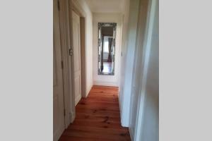 an empty hallway with a wooden floor and a mirror at Green Garden meets Blue sea for 2 people in Dingle