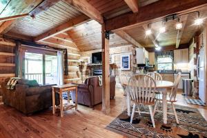 a kitchen and living room with a table and chairs at Bear Claw Cove - hot tub, jacuzzi, fireplace, view in Sevierville