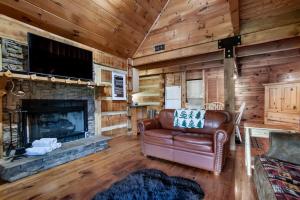 a living room with a leather couch and a fireplace at Bear Claw Cove - hot tub, jacuzzi, fireplace, view in Sevierville