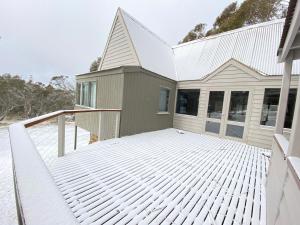 a snow covered deck in front of a house at Verandering in Dinner Plain