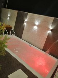 uma piscina com água vermelha e luzes num quarto em CASA TEMPORADA BARREIRINHAS 2 Quartos em Barreirinhas