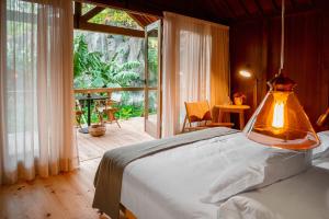 a bedroom with a bed and a large window at Senhora da Rosa, Tradition & Nature Hotel in Ponta Delgada