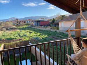 un hombre sentado en una hamaca en un balcón con vistas al campo en La bicicleta del Moncayo, en Alcalá de Moncayo