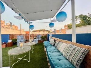 un patio con sofá, 2 mesas y sillas azules en Casa Adrián, Águilas, Costa Cálida en Águilas