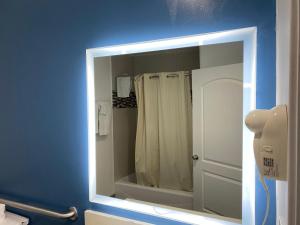 specchio in bagno con tenda doccia di Cozy motel a Lynwood