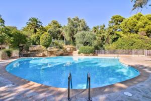 a large swimming pool in a yard with trees at LE MIRAMAR Nice - Clim, Parking, Wifi et piscine in Nice