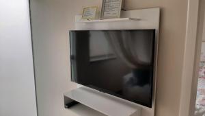 TV de pantalla plana colgada en la pared en Mix aparts -Apartamento perfeito em Tijucas -SC en Tijucas