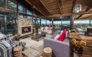 a living room with couches and a fireplace at Kariega Game Reserve Main Lodge in Kenton on Sea