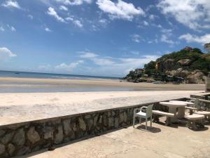 a table and chairs sitting on the beach at Rimtalay Home Huahin in Hua Hin